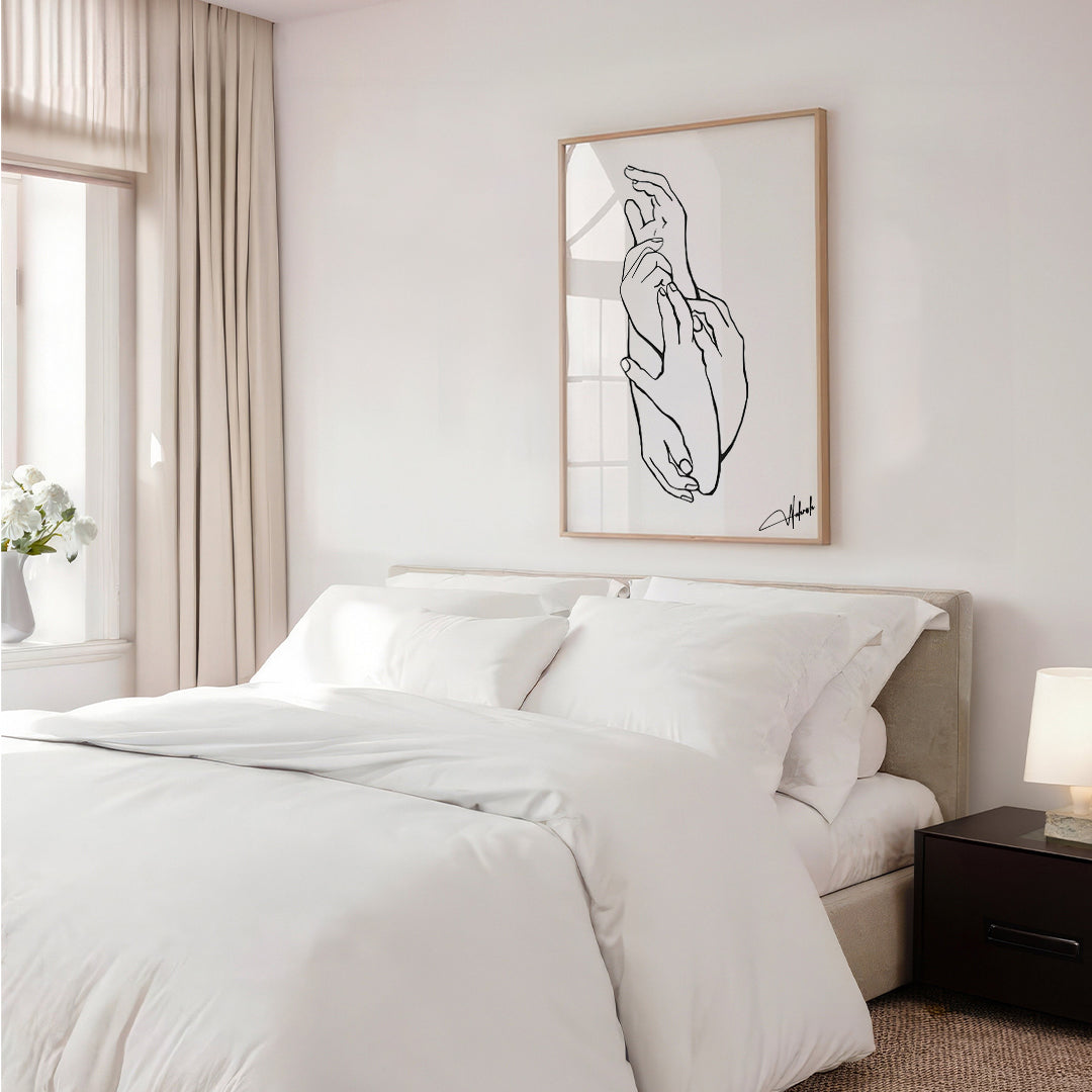 Black and white line art of two hands holding framed on a minimal modern wall

