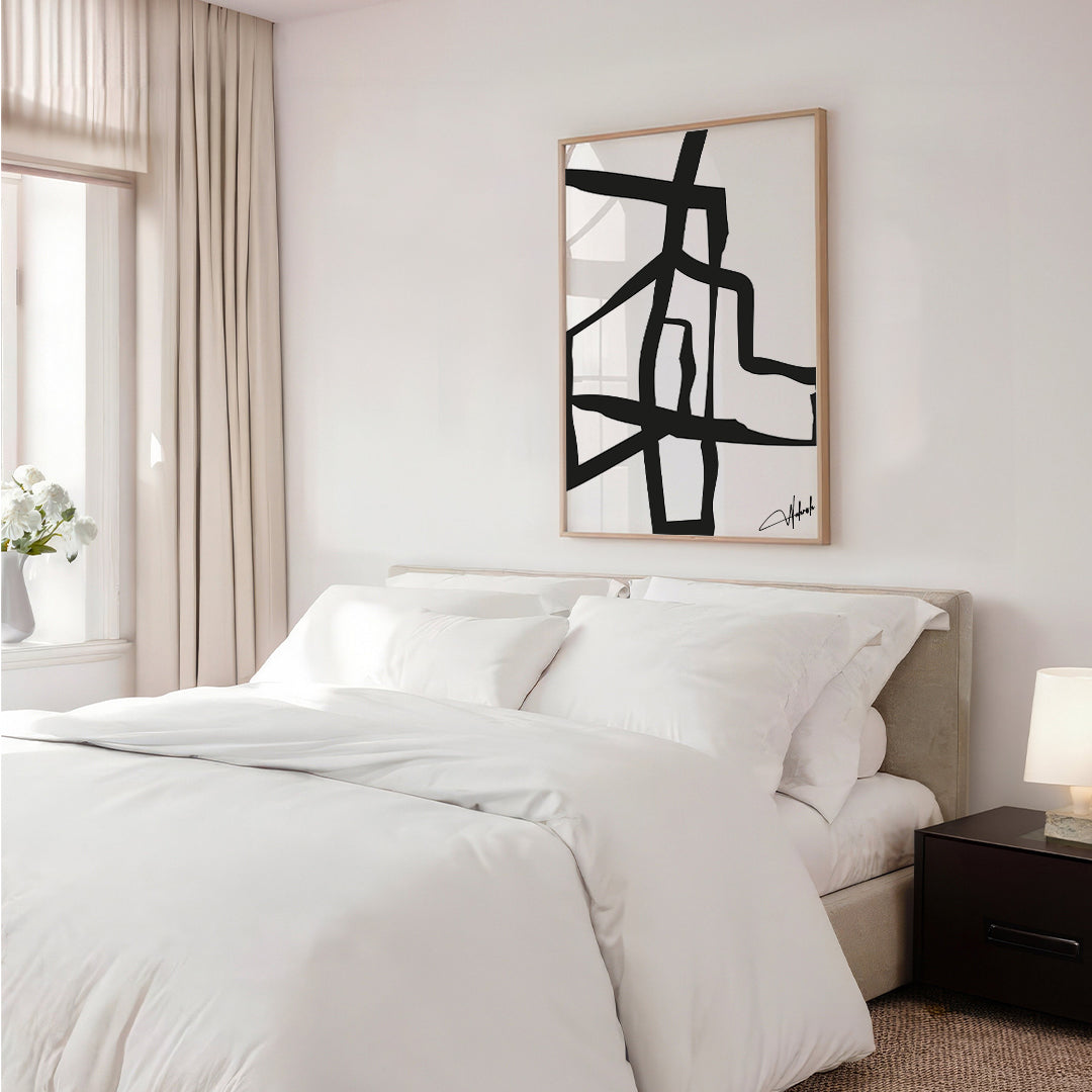 Abstract black intersecting line artwork on matte canvas in a modern workspace setup

