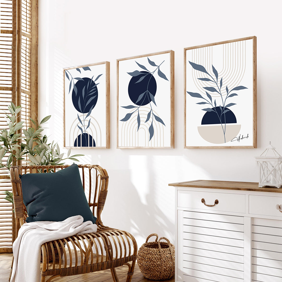Set of 3 minimalist botanical wall art prints with navy and neutral tones, framed and displayed in a modern living room.